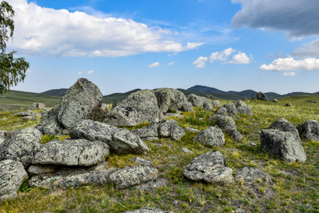 Mountain landscape with large stones and green grass under a blue sky. Khakassia, Siberia, Russia, Sahsyrの写真素材