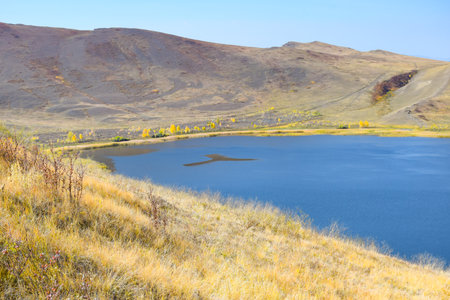 Autumn landscape with lake, yellowed grass and blue sky. Khakassia, Siberia, Russia, Sahsyrの写真素材