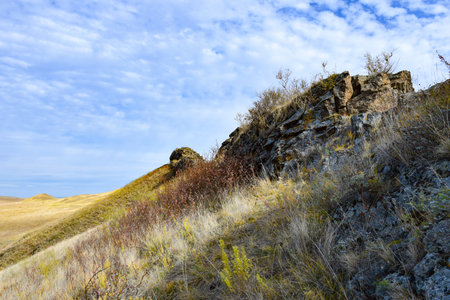 rocky hillside in autumn under a blue sky with white clouds. Khakassia, Siberia, Russia, Sahsyrの写真素材