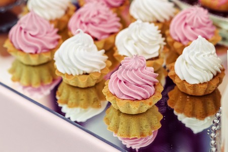 Cakes at the wedding, white and pink on a mirrored trayの写真素材