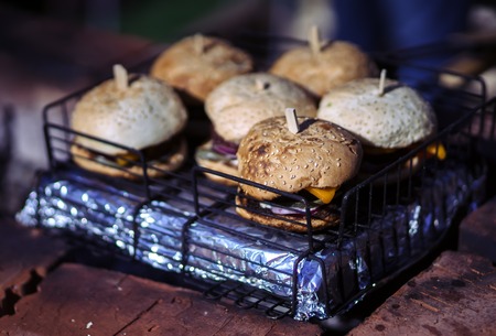 Hamburger with cheese and onions toasted on an open fireの写真素材