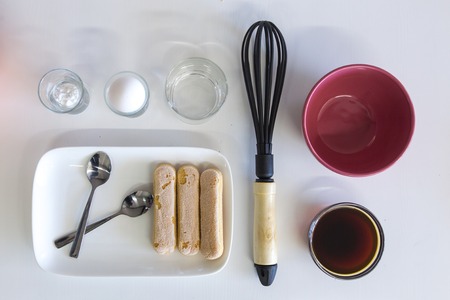 The ingredients for the dessert tiramisu, laid out on white paper.の写真素材