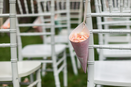 Bag of rose petals on the chiavari chair. Plenty of chairs in the backgroundの写真素材