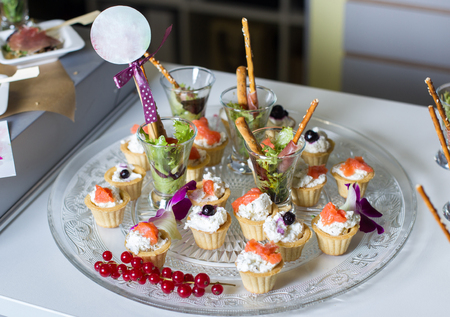 Puff pastry with cream cheese and salmon placed on a glass dish decorated with red currantsの写真素材