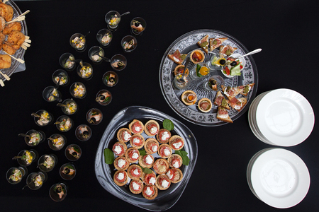 Salmon rolls stuffed with cheese sprinkled sesame seeds, laid on a transparent glass plate. Shot from aboveの写真素材