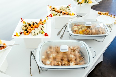 Catering food wedding, white beautiful table. Shrimp, kebabs rolls