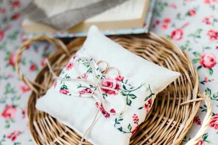 Wedding rings on a cushion handmade. Natural fabrics. It is all on a wicker tray.