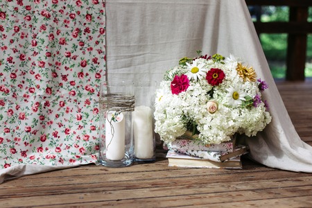 Floral arrangement of white flowers at the wedding table. The bouquet is to decorate with books. Lovely wooden floor boards.の写真素材