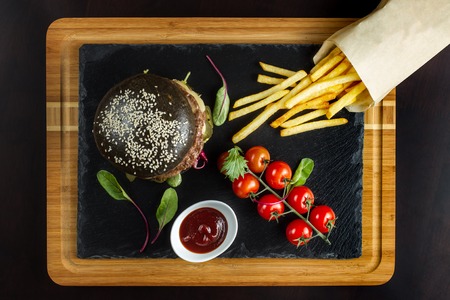 Black double hamburger made from beef with jalapeno pepper, cheese and vegetables. Top view.の写真素材