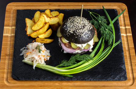 Black hamburger with onions and cucumbers on stone table with black background-2の写真素材