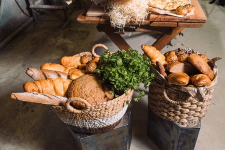 Wicker baskets with bread and greens.の写真素材