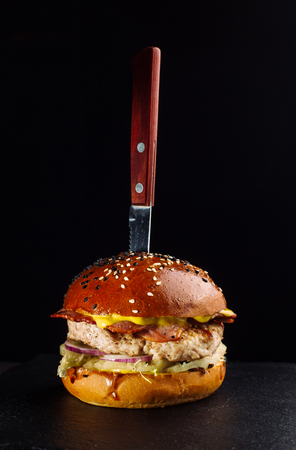 Close-up of delicious fresh home made burger with lettuce, cheese, onion and tomato.の写真素材