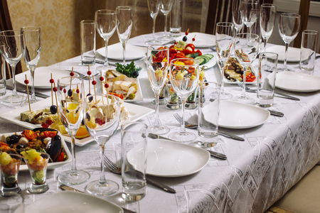 General form of a banquet table. Cheese plate in the middle. Fish dishes, zucchini rolls, vegetable salad.の写真素材