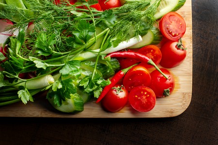 Wooden plank with vegetables for a vegetarian salad.の写真素材