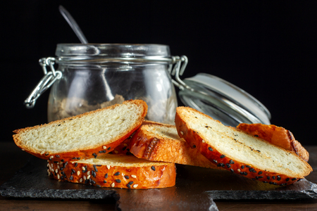 Toasts are laid out on a black slate, close-up of a bun with sesame.の写真素材