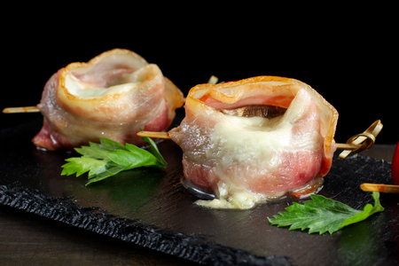 Bacon Wrapped Mushrooms Stuffed on black slate.の写真素材