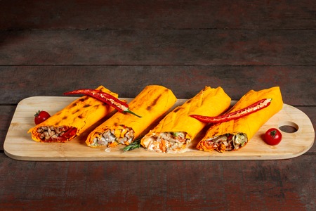 Ready shawarma cut in half on wooden board.の写真素材
