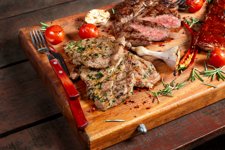 Grilled meat, ribs and vegetables on rustic wooden table.の写真素材