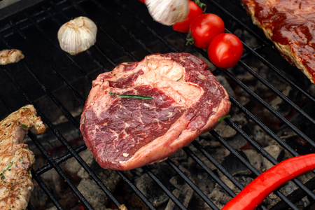 Beef steaks on the grill with flames.の写真素材