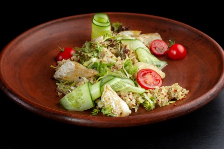 Fish with fresh green leaves salad and quinoa.の写真素材