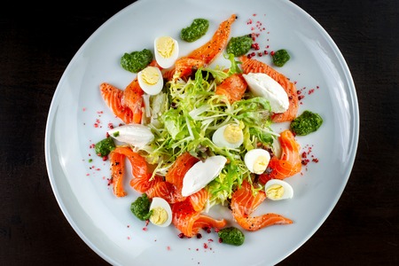 Salad from eggs, greens and trout. On white plate.の写真素材