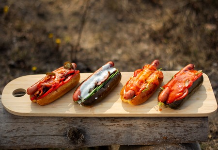 Hot dogs lie in the sun backlight on the wooden plate.の写真素材