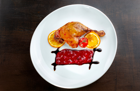 duck wings with cranberry sauce on a white plate.の写真素材
