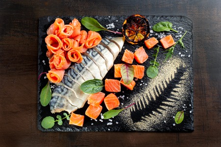 Mackerel, salmon pieces. Laid out on black slate.の写真素材