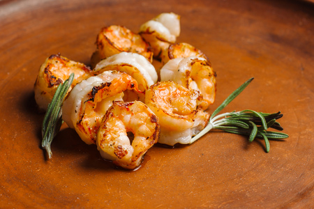 Grilled tiger shrimps with spice on a clay plate.の写真素材