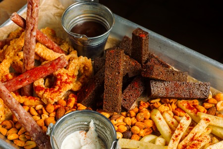 Snack to beer. Beer metal tray with a mountain of food.の写真素材