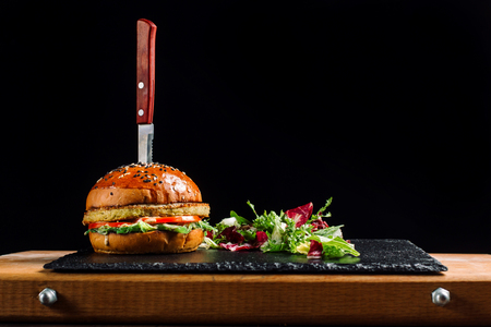 Burger with potato patty on black slate.の写真素材