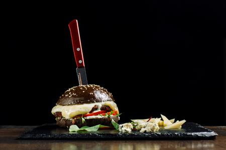 Black Burger with Cheese dor blue and salad on black slate.の写真素材