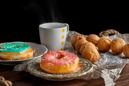 Dessert with sweet pink doughnuts and cup of tea.の写真素材