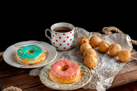 Dessert with sweet pink doughnuts and cup of tea.の写真素材
