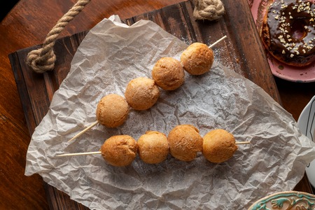 Cottage cheese balls on wooden skewers, lie on craft paper.の写真素材