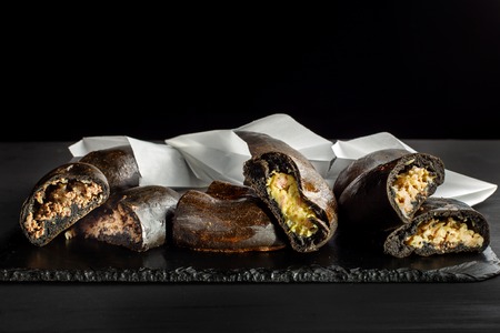 Patties stuffed with cabbage, potatoes and meat. Laid on a black slate.の写真素材