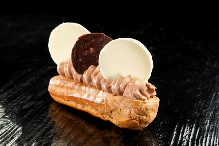 Choux pastry, with cream and chocolate on a black background.の写真素材