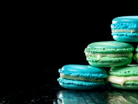 Delicious macaroons isolated on black background. French sweet cookie.の写真素材