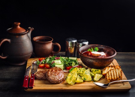 Lunch with fried meatballs, soup with meat and potatoes on a rustic.の写真素材