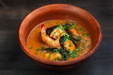 Spicy french soup with seafood in a clay plate.の写真素材