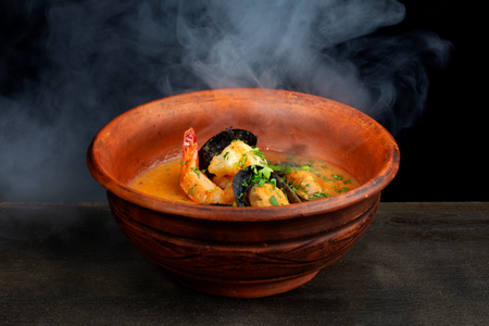 Spicy french soup with seafood in a clay plate.の写真素材