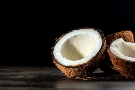 Coconut halves on a black background. Back light.