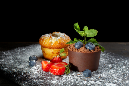 Vanilla cap cake and chocolate dessert in a pot on a black slate covered with powdered sugar-2.の写真素材