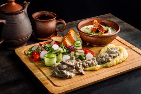 Pea soup with smoked meat in a clay plate, meat goulash with mushrooms and sauce-2.の写真素材