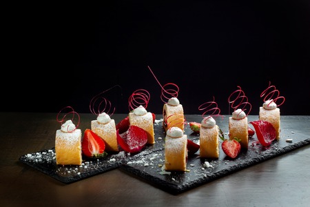Homemade cake roll with strawberry cream a on a black slate.の写真素材