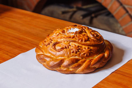 Round loaf of wedding bread. Russian customs and traditions. In the background is a Russian stove.の写真素材