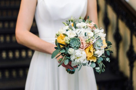 Bride holding the wedding bouquet, with succulent flowers, close-up.の写真素材