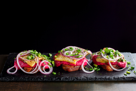 Three smoked salmon sandwich laid out on a black slate-3.の写真素材