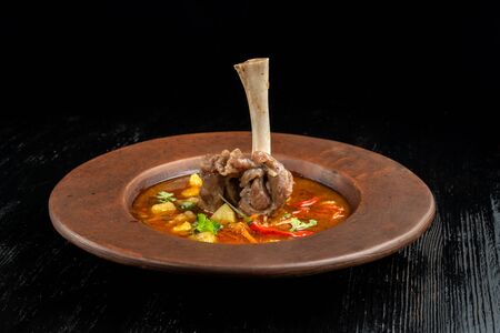 Soup with pepper, potatoes and bone with meat.の写真素材