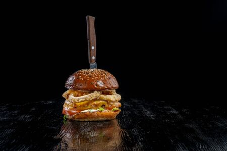 Gourmet craft bacon cheeseburger with tomatoes  onion ringsの写真素材
